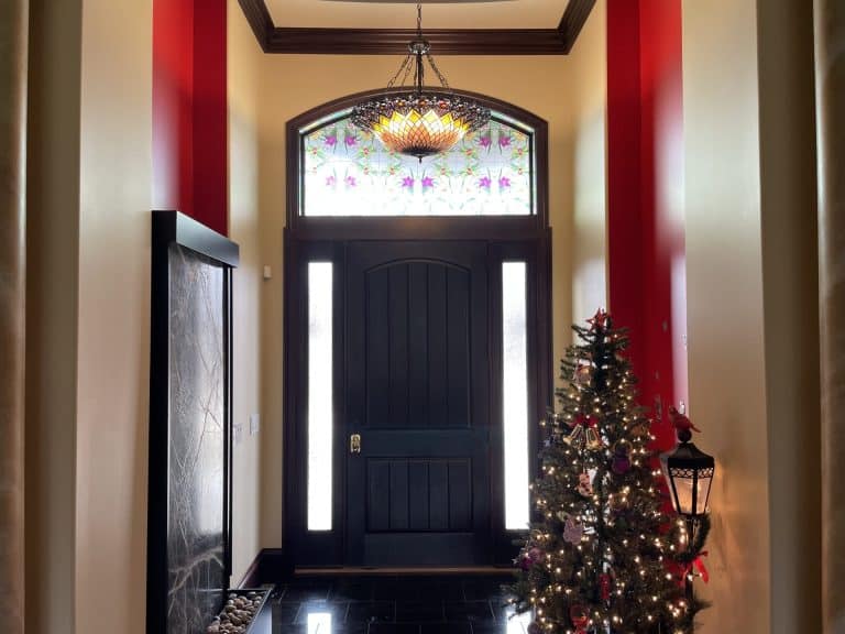 Entry door with decorative window film above and on the sides.