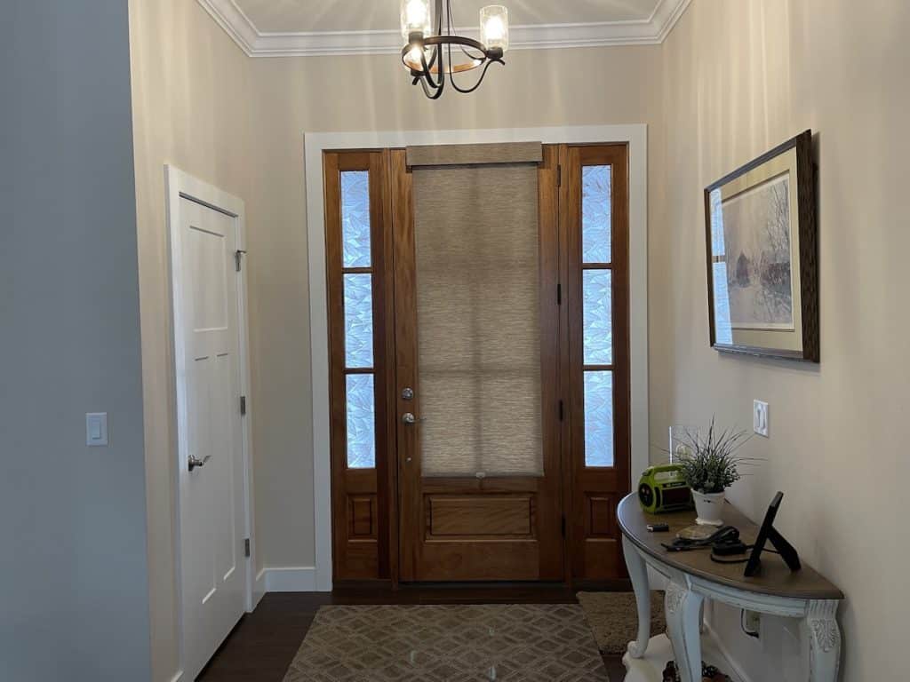 Entry door with decorative window film on the glass and side windows.